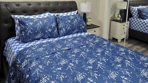 Une chambre à coucher avec un grand lit, une table de chevet, une lampe et deux tableaux accrochés au mur.