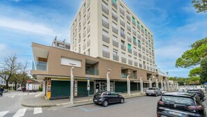 Ein mehrstöckiges Hotel im modernen Stil, mit flachem Dach, großen Fenstern und einem Parkplatz.