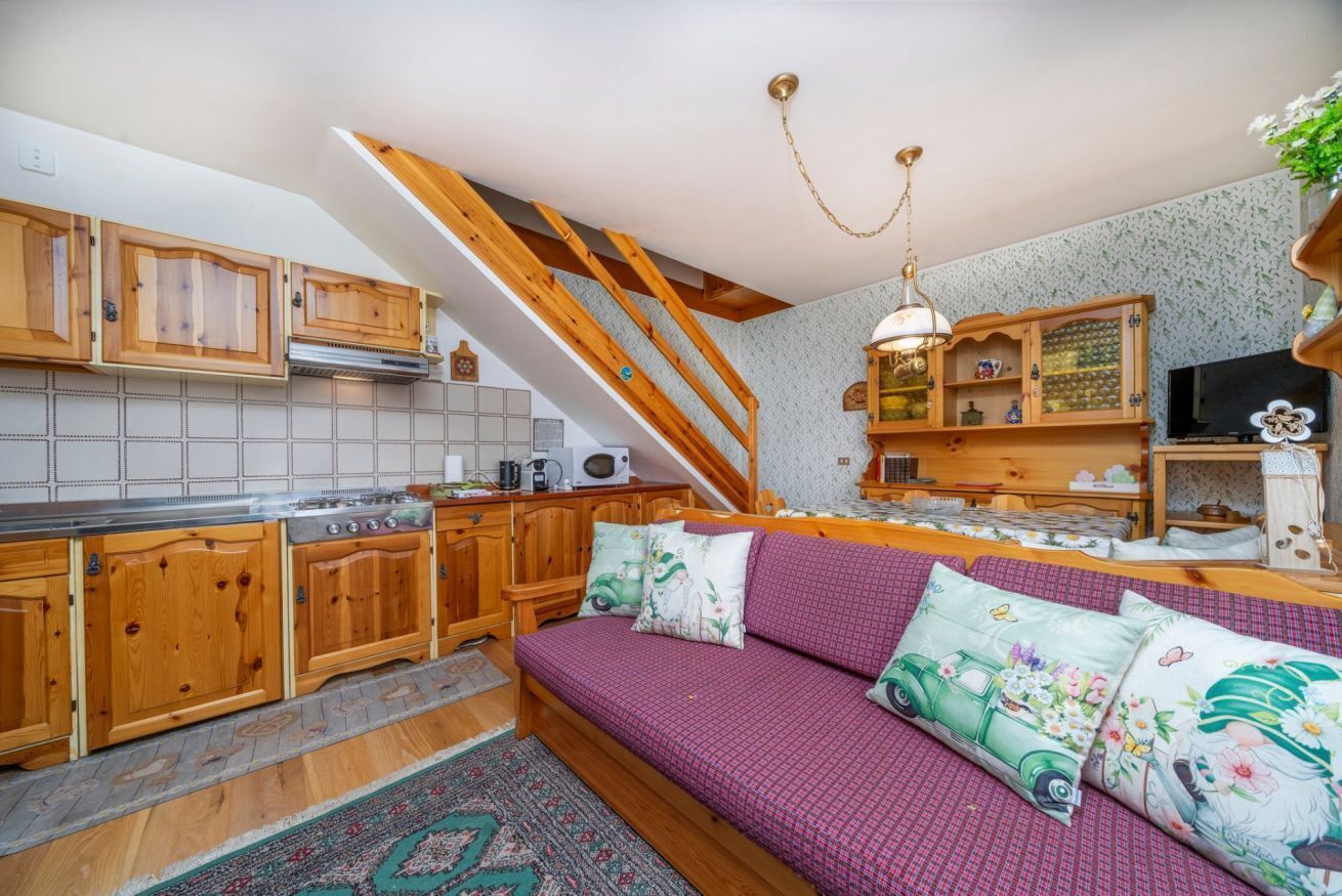 A cozy kitchen with wooden cabinets, a built-in stove, and a dining area with a bench.