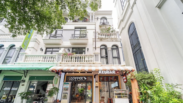 Una cafetería llamada 'Coffee' con terraza, una motocicleta estacionada afuera y un letrero de Kenbar.