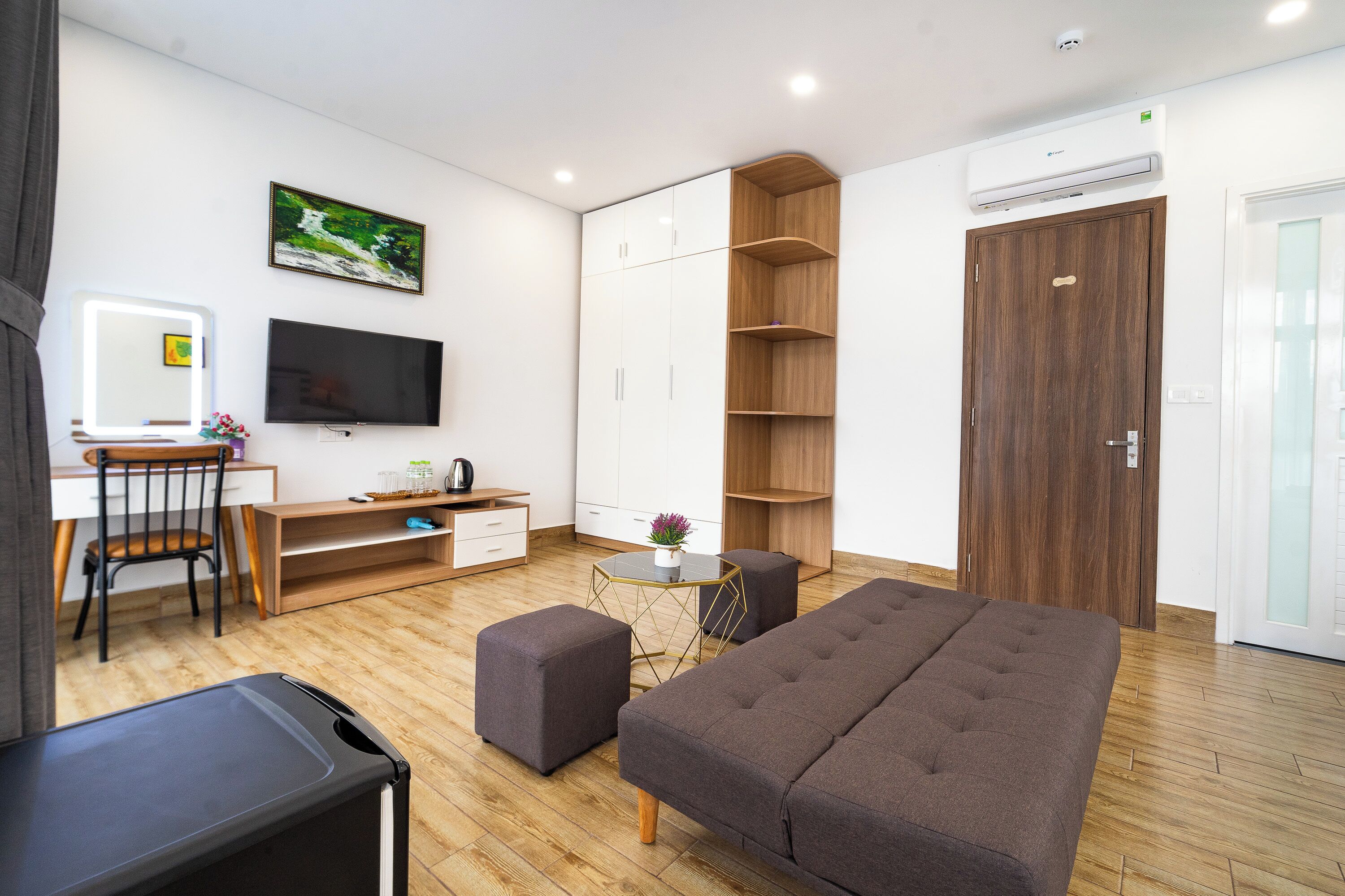 A modern bedroom with a bed, a desk, a chair, a TV, and a wardrobe.