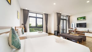 Una habitación de hotel moderna con dos camas, un sofá, un televisor y un escritorio con una silla.