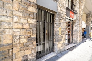 A stone building with a metal gate, a sign reading 'LEGAMIL,' and a visible storefront.