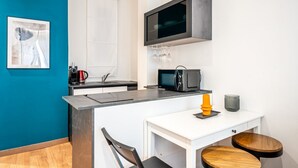 A modern kitchen with a microwave, coffee maker, and wine glasses on the counter. - GuestHost - Old Bridge Lovely Apartment (Firenze)