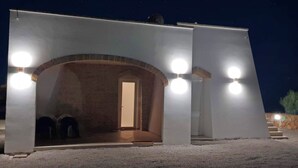Un bâtiment doté d’une grande entrée en arc de cercle, d’une porte et de trois hublots ronds sur la façade extérieure.