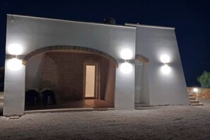 A building with a large arched entrance, a door, and three round lights on the exterior.
