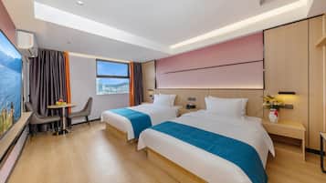 A modern hotel room with two beds, a desk, and a chair.