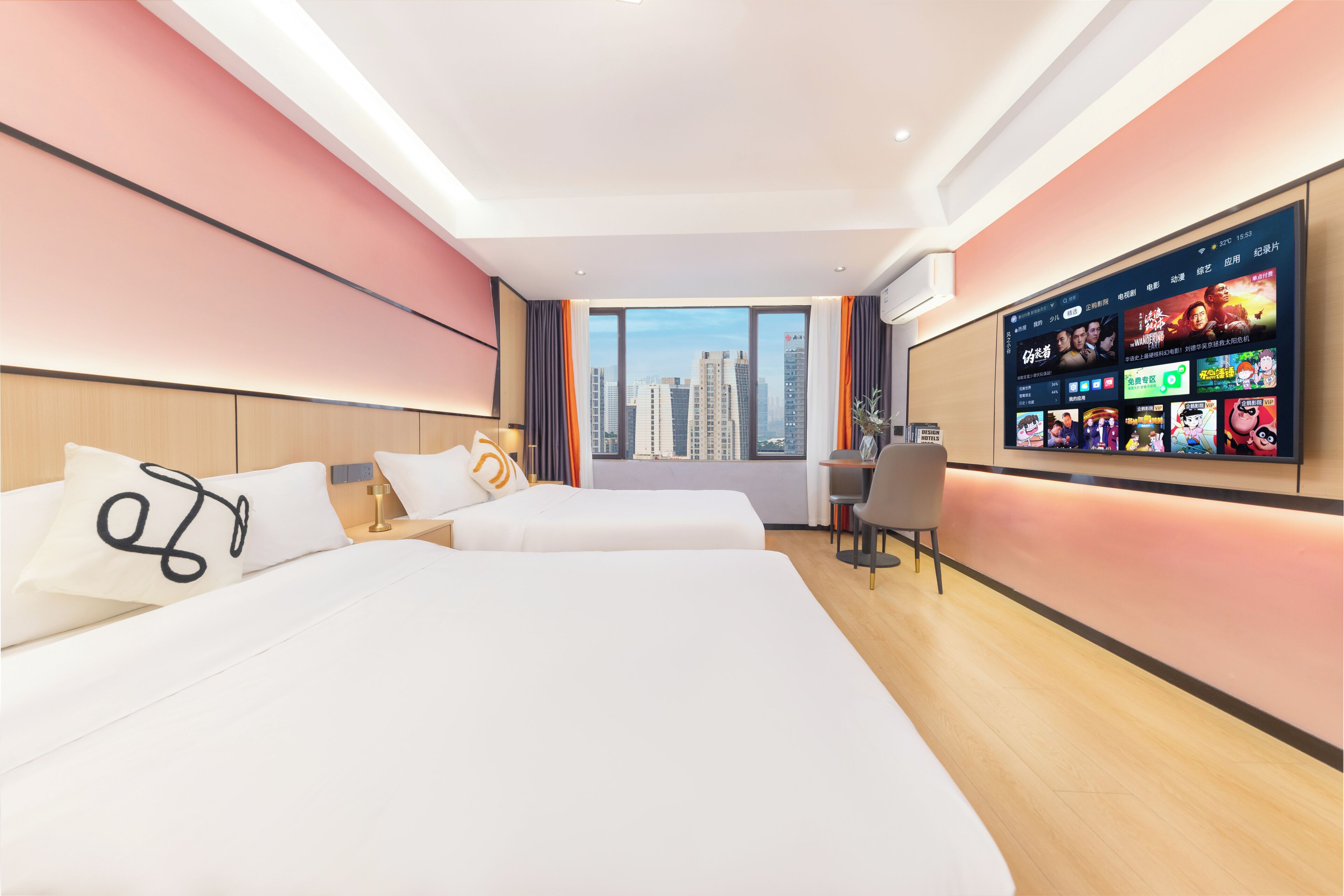 Habitación de hotel con dos camas, un escritorio, un televisor montado en la pared y vistas a edificios altos.
