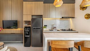 Une cuisine moderne dotée d’un réfrigérateur encastré, d’une cuisinière et d’un grand îlot central.