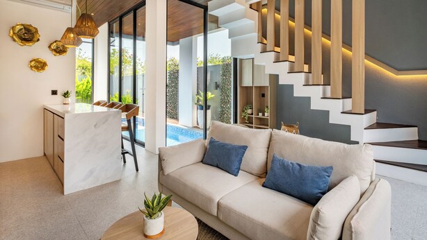 Un salon moderne avec un canapé, une table basse et un escalier à marches en bois.
