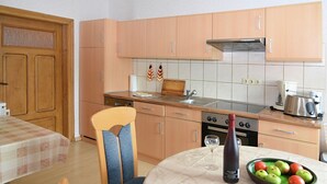 Una cocina funcional con armarios de madera, una mesa de comedor y un frutero.