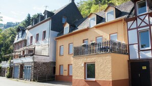 En række boliger med forskellige arkitektoniske stilarter, heriblandt et hus med en stenfassade og et hus med en bjælkebalkon.
