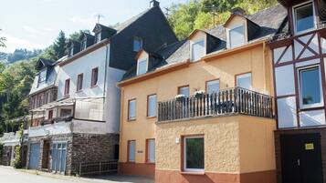Eine Reihe von Wohnhäusern mit unterschiedlichen Baustilen, darunter ein Haus mit einer Steinaußenwand und ein Fachwerkhäuschen mit Balkon.