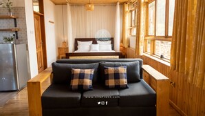 Une pièce confortable avec un lit, un canapé et un coin cuisine.
