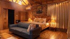 Ein gemütliches Zimmer mit einem Bett, einer Couch und einer Holzbalkendecke.