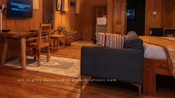 Un intérieur rustique en bois, avec un canapé, un téléviseur et un coin repas.