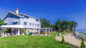 A large two-story house with a covered patio area and a view of the sea. - St. Anastasia Hotel (Burgas)