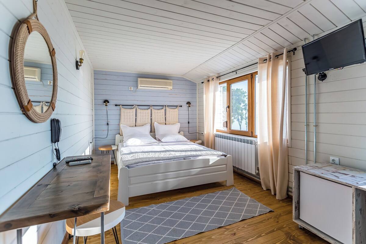 A bedroom with a bed, bedside table, and a TV.