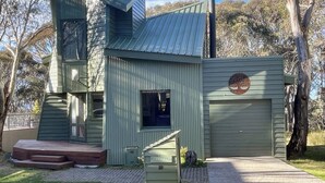 A modern, two-story building with a metal roof and a garage door. - Faraway-Chalet (Dinner Plain)