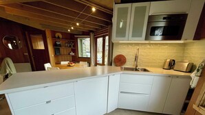 A modern kitchen with white cabinetry, a built-in oven, and a sink. - Faraway-Chalet (Dinner Plain)