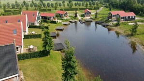 A lakeside property with multiple houses, a dock, and a grassy area.