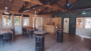 Um interior rústico com uma mesa de jantar de madeira, cadeiras, um espaço de bar e uma cozinha.