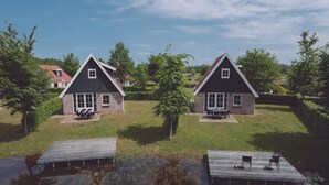Duas casas com gramado e um píer de madeira.