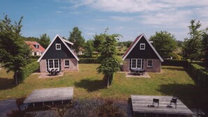 Two houses with a grassy yard and a wooden dock extending into a body of water. - Large Countryside Group Stay (Bant)