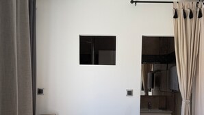 Een compacte, moderne keuken met een houten aanrecht, een inbouwfornuis en een klein spoelgedeelte.