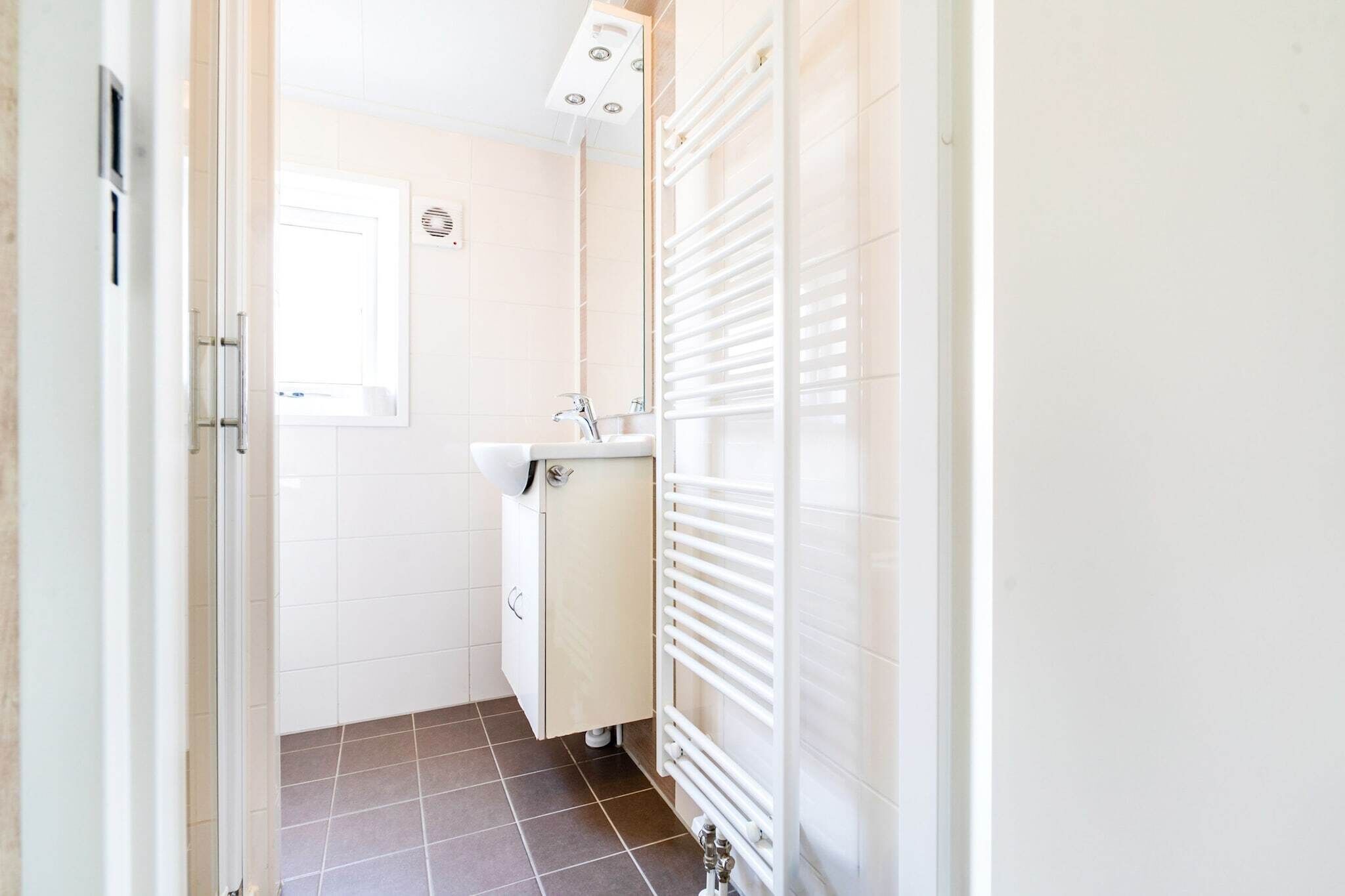 Une petite salle de bain comprenant des toilettes, un lavabo et un radiateur.