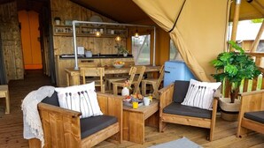 A cozy wooden interior with a dining area, wooden furniture, and a view through a tented window.