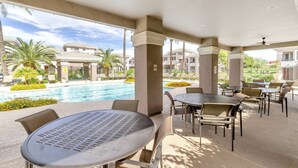 A poolside area with tables and chairs, a pool, and a view of the resort buildings. - Single Story Level w/ Heated Pool/Spa/Fitness Rm, Garage, Kierland's Fine Dining/Shopping+FREE GOLF (Scottsdale)