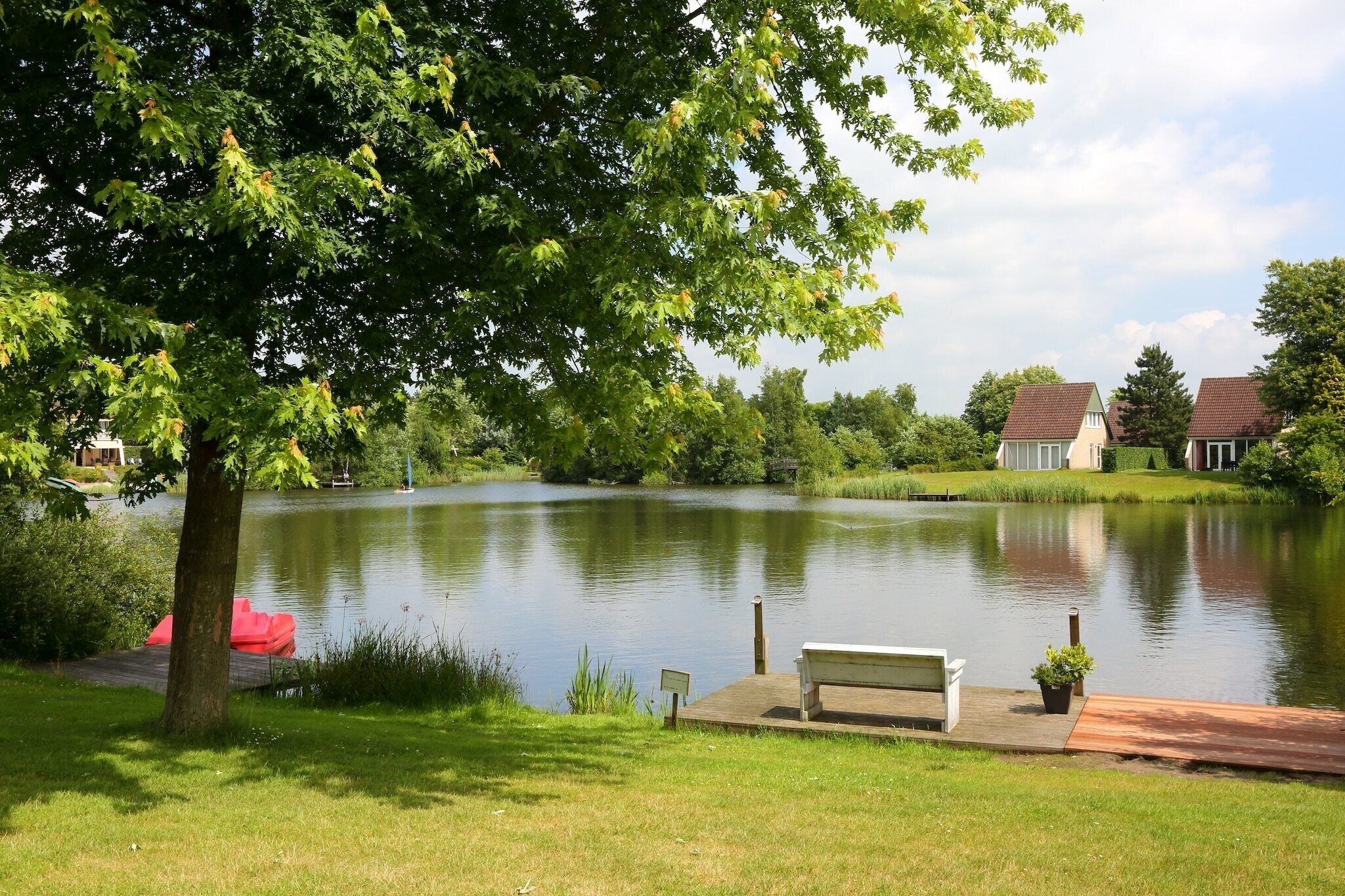 A serene lakeside setting with a bench and a small dock.