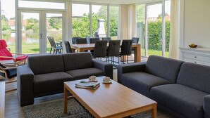 Una sala de estar moderna con un sofá, una mesa de centro y un comedor con sillas y una mesa.