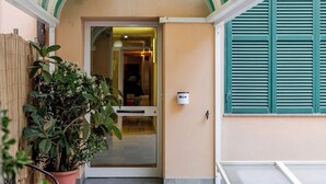 Un couloir avec un plafond à rayures, une plante en pot et une porte donnant sur une pièce.