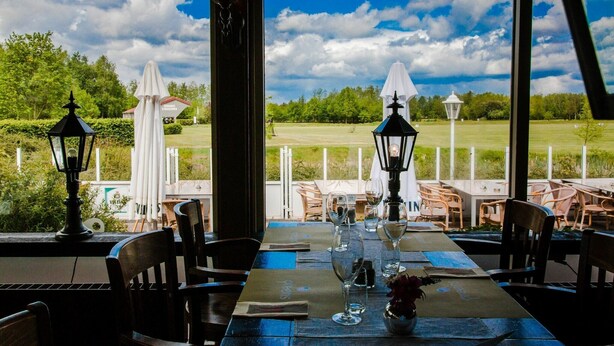 An outdoor dining area with tables set for two, chairs, and decorative lanterns. - Nature Escape w/ Balcony (Vlagtwedde)
