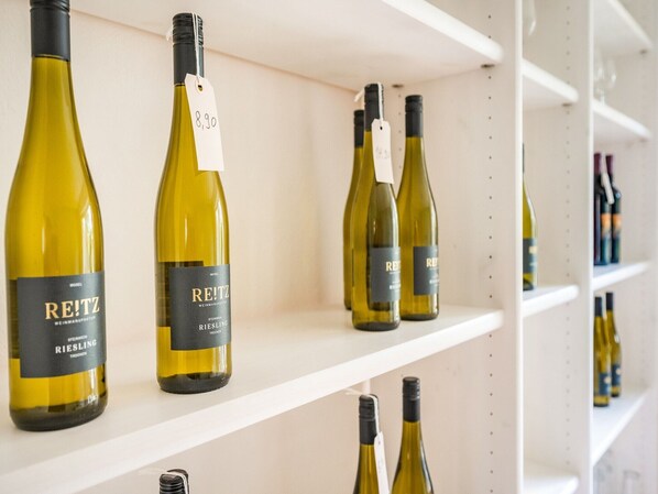 Ein Weinregal mit Flaschen Riesling und anderen Weinen.