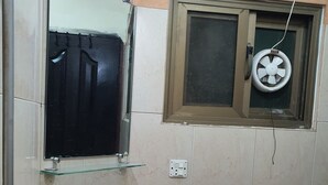 Un baño con un lavabo blanco, un espejo y una ventana con ventilador.