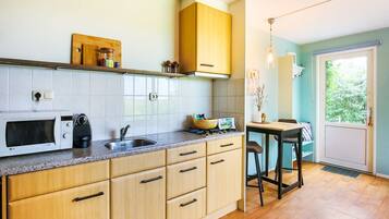 Een koelkast, een magnetron, een koffiezetapparaat/waterkoker, eettafels