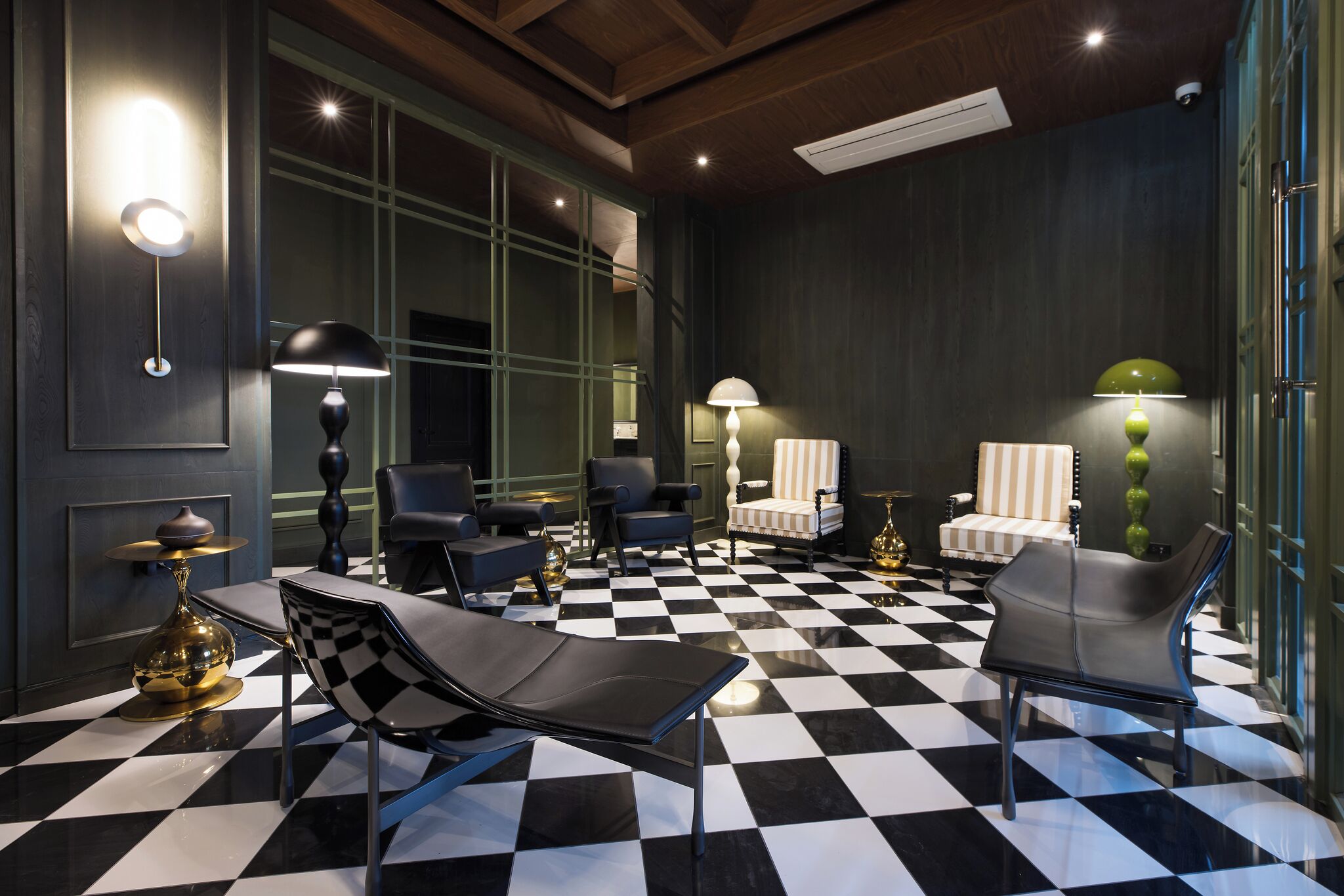Un interior moderno con suelo a cuadros, sillones cómodos e iluminación ambiental.