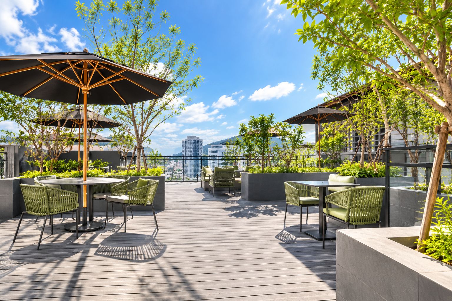 An outdoor patio with round tables and chairs, umbrellas, and greenery.
