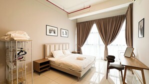 A modern hotel room with a bed, a desk, and a chair. There is a wardrobe with shelves and a hanging rack. - 3 Towers Jln Ampang by Airhost (Kuala Lumpur)