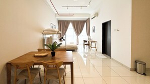 A modern hotel room with a dining area, a bed, and a view of the city. - 3 Towers Jln Ampang by Airhost (Kuala Lumpur)