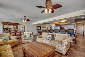 A spacious living area with a large sofa set, a wooden coffee table, and a ceiling fan. - New to Rental! Gorgeous 6th Floor Oceanfront Condo at North Beach Resort-$300 FREE Activities Daily (North Myrtle Beach)