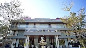 A modern hotel with a central fountain, multiple balconies, and a clear sky. - The Green Icon Resort (Rishikesh)