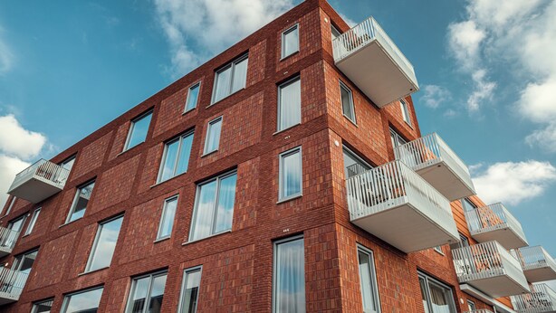 A multi-story red brick building with balconies and large windows. - Trompstraat (Eindhoven)