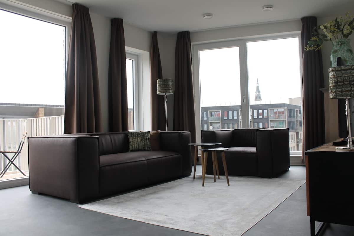 A modern living room with a sofa, a coffee table, and a TV stand.