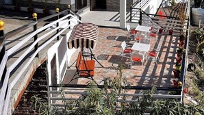A multi-story villa with a balcony, outdoor seating area, and a sign indicating it is a 'Classic Hills Villa'. - Classic Hills Villa Mussoorie (Mussoorie)