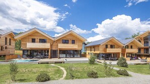 A modern wooden cabin with a swimming pool, outdoor seating, and a clear sky. - Glamping Tent in Zeewolde with BBQ (Zeewolde)