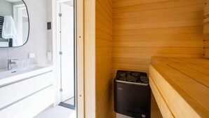 A modern bathroom with a wooden sauna, a large mirror, and a white sink. - Water Lodge in Lelystad with Private Sauna (Zeewolde)
